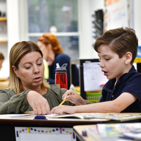 A teacher sitting with a child