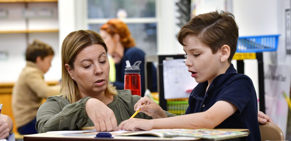 A teacher sitting with a child