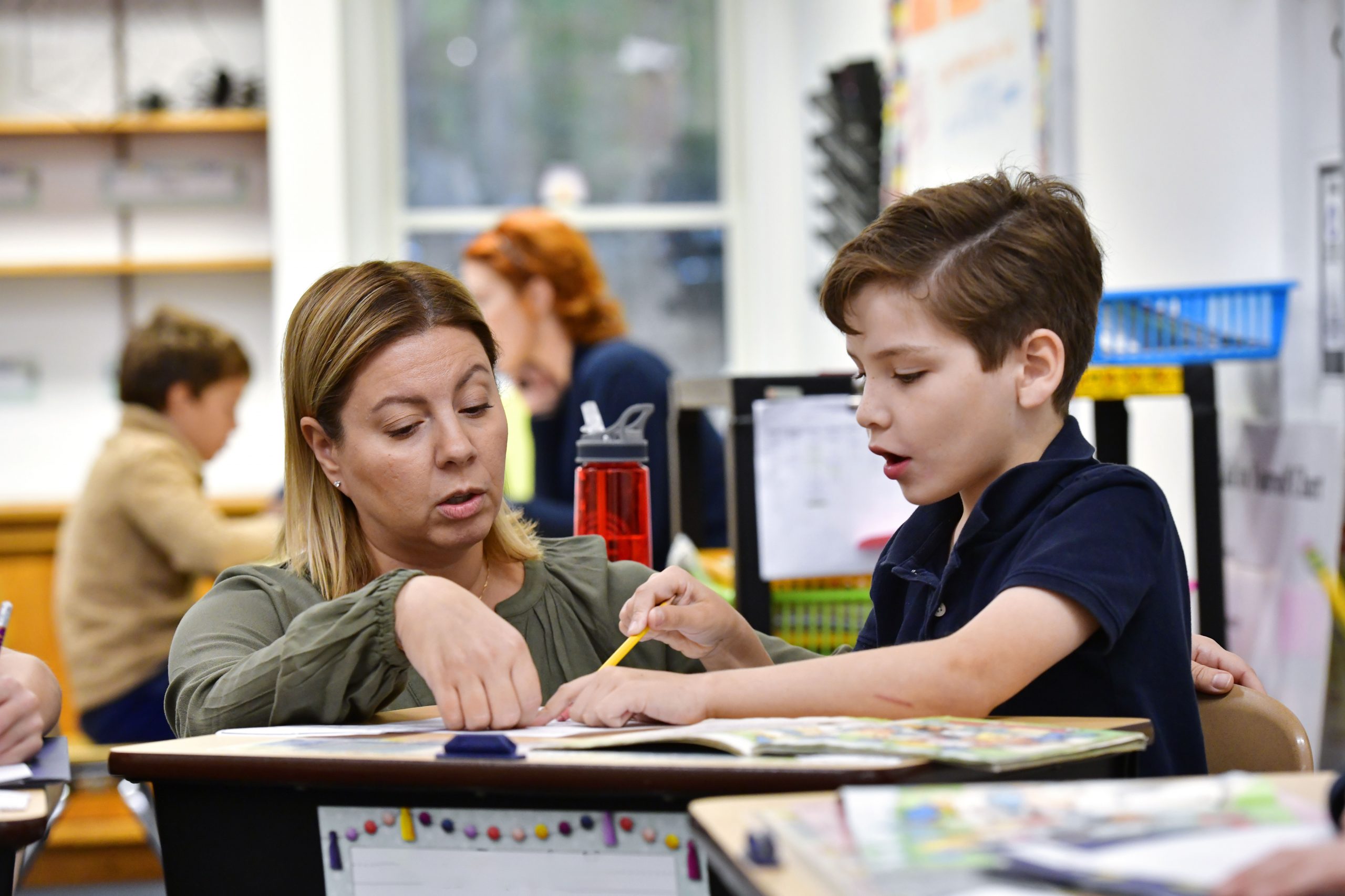 A teacher sitting with a child